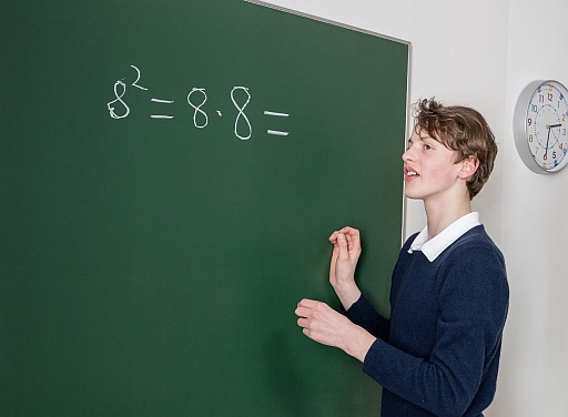 Paul schreibt an der Tafel: 8² = 8•8 =